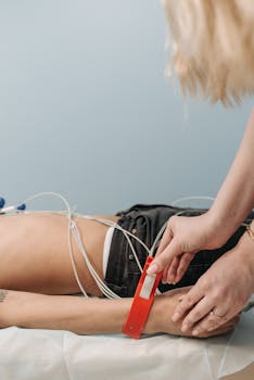 A healthcare professional attaches ECG sensors to a patient in a clinic setting.