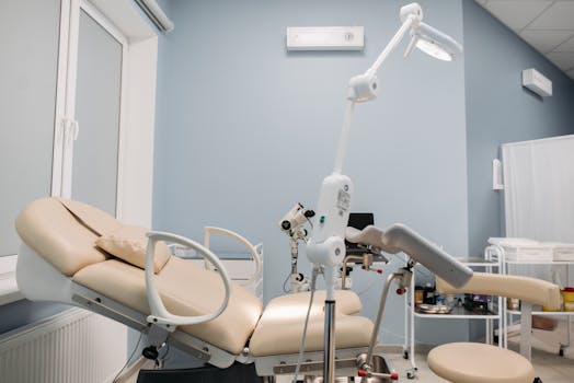Bright and clean interior of a modern clinic with medical equipment and examination table.