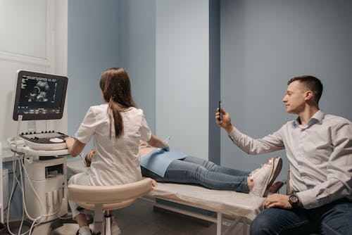 Man Taking Photo of Ultrasound Screen in Examination Room