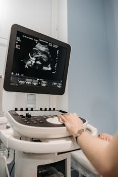 Healthcare professional conducting an ultrasound scan in a medical facility.