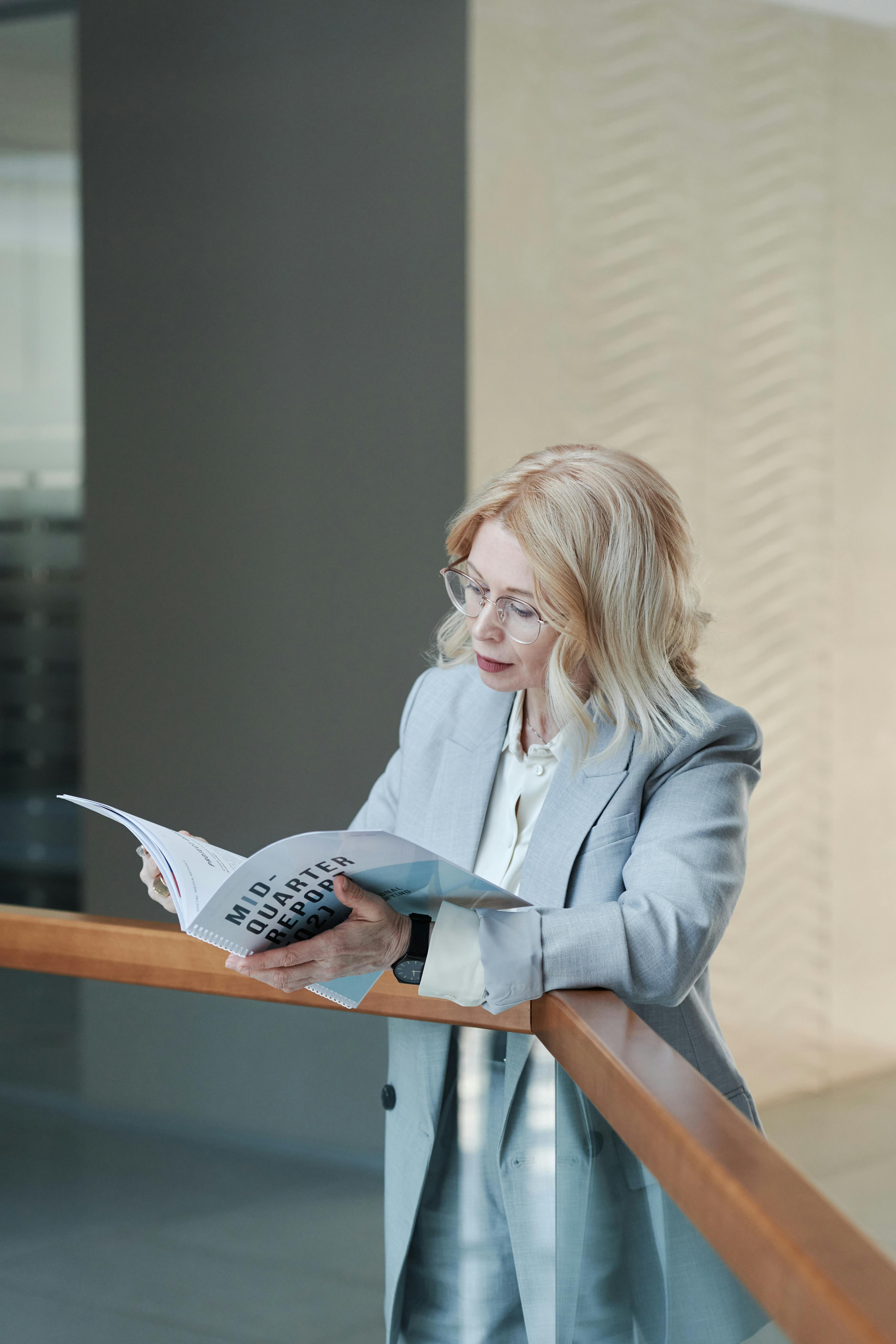 a woman in gray blazer reading a book