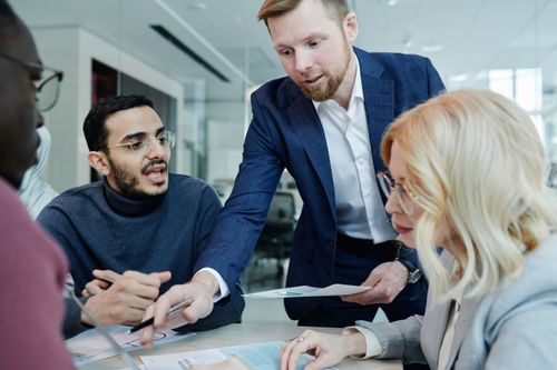 Free A diverse group of colleagues discussing ideas during a team meeting in a modern office setting. Stock Photo