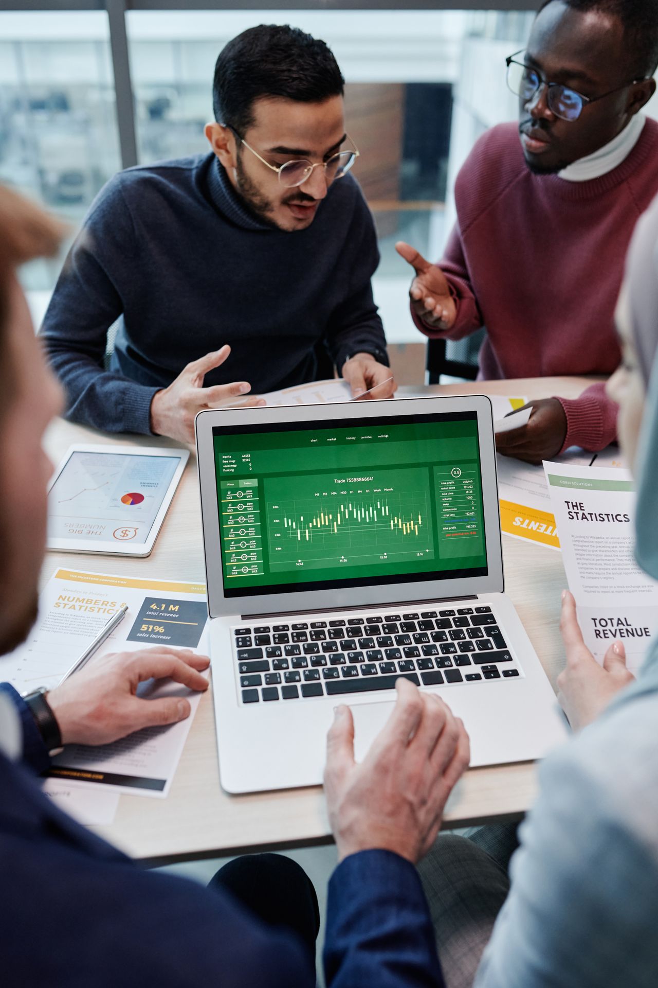 Financial services professionals reviewing charts and business data together in a real office