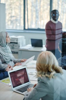 A diverse group of colleagues in a modern office discussing a presentation.