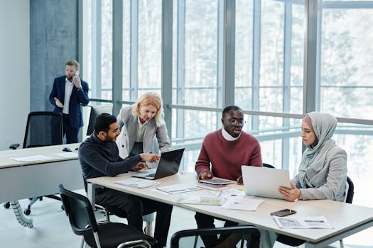 Multicultural group of professionals discussing ideas in a bright, modern office setting.