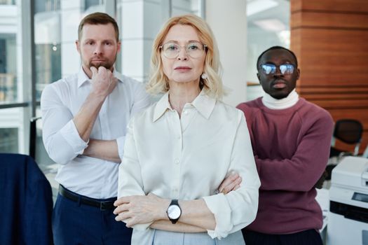 Confident multiethnic team posing in a modern office setting showcasing diversity and professionalism.