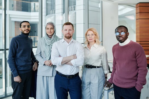 A diverse group of professionals posing confidently in a modern office environment.