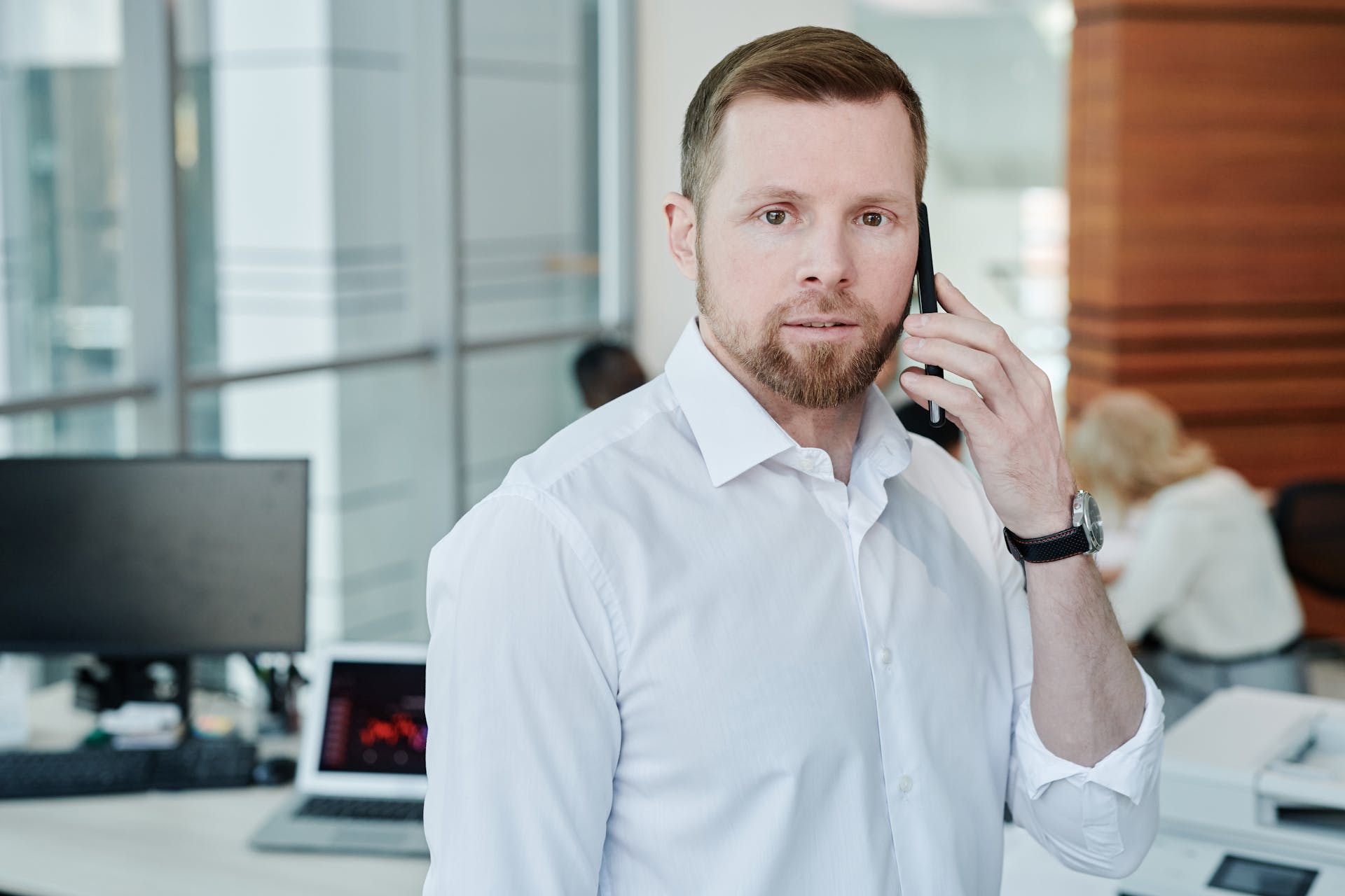 A Man in White Button-Up Shirt Having a Phone Call