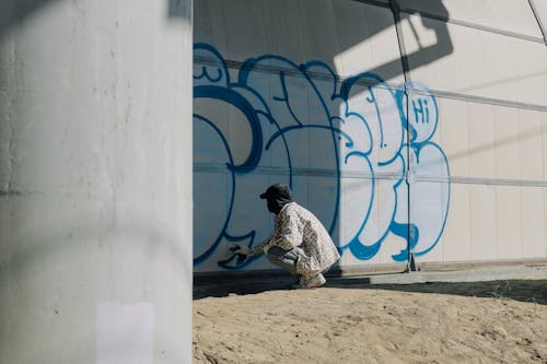 Person Doing Graffiti on Wall