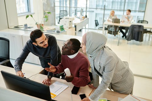 Men and Woman Discussing in Front of the Black Monitor