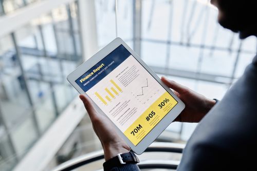 Free Businessman reviewing financial statistics on a tablet indoors. Stock Photo