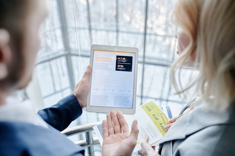 A Person Showing A Woman His Tablet