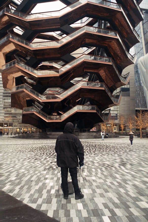 Man near geometrical building of Vessel in Hudson Yards