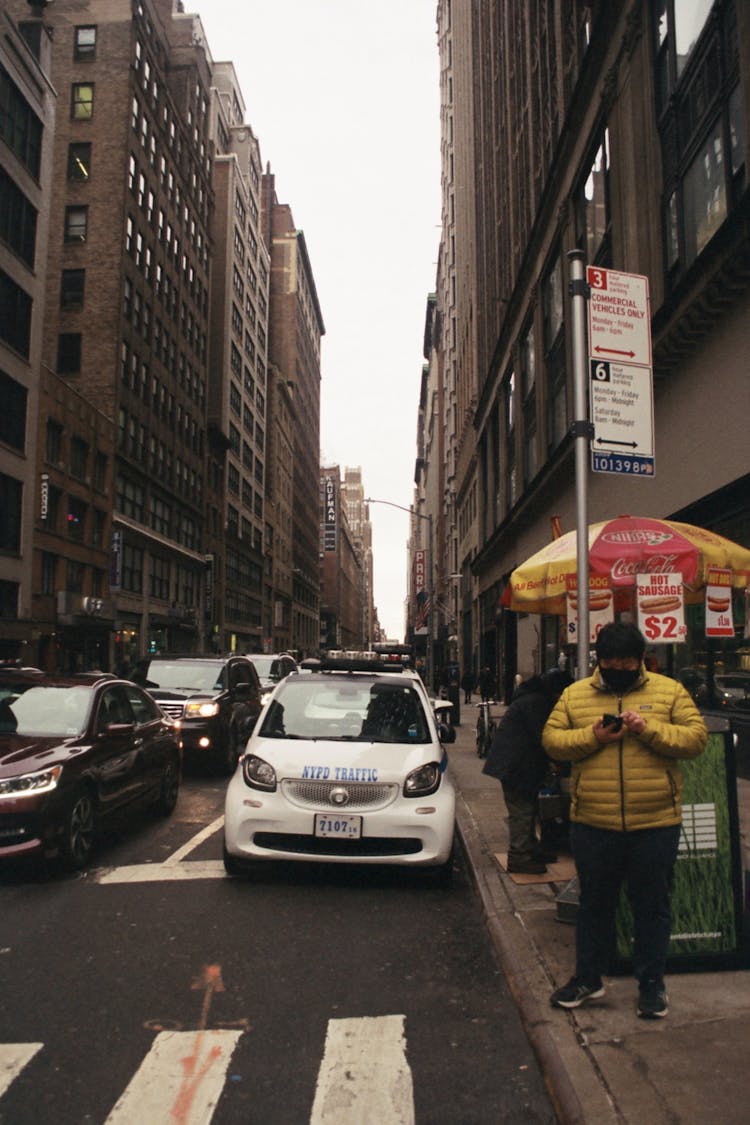 Man In Outerwear And Medical Mask Using Smartphone Near Road