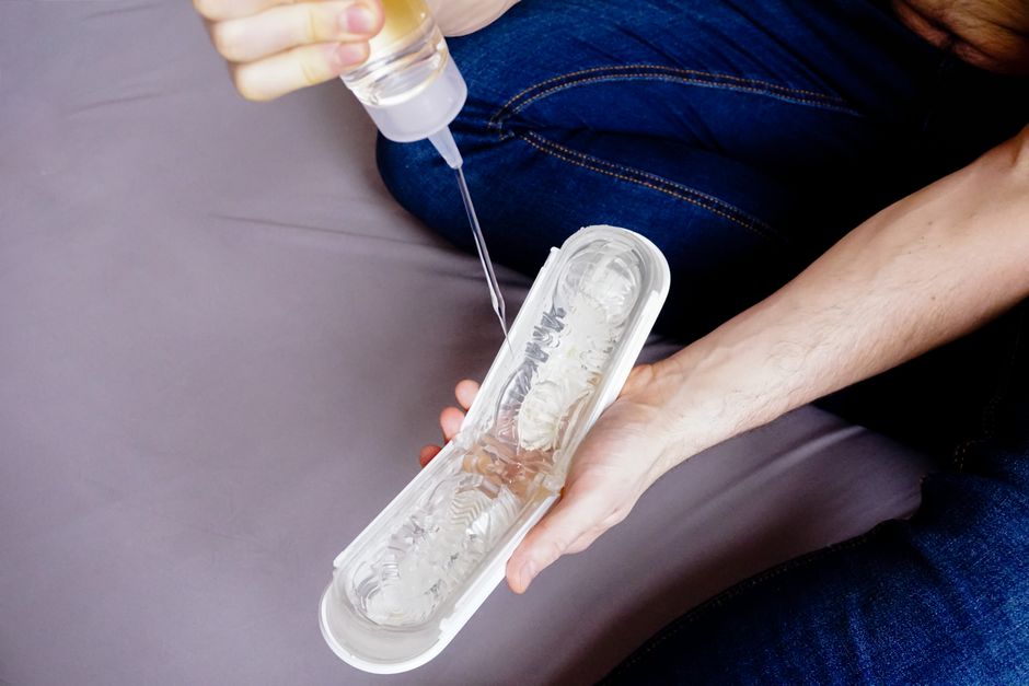 person applying lubricant to a sex toy - water based lubricant person applying lubricant to a sex toy - water based lubricant