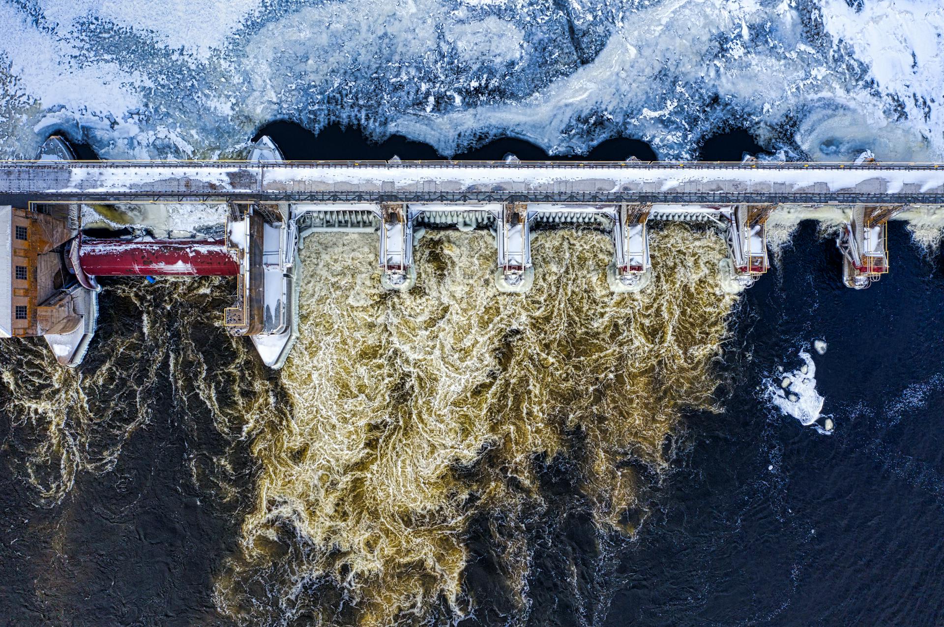 Dramatic aerial shot of a frozen dam with rushing water in winter in Minnesota.