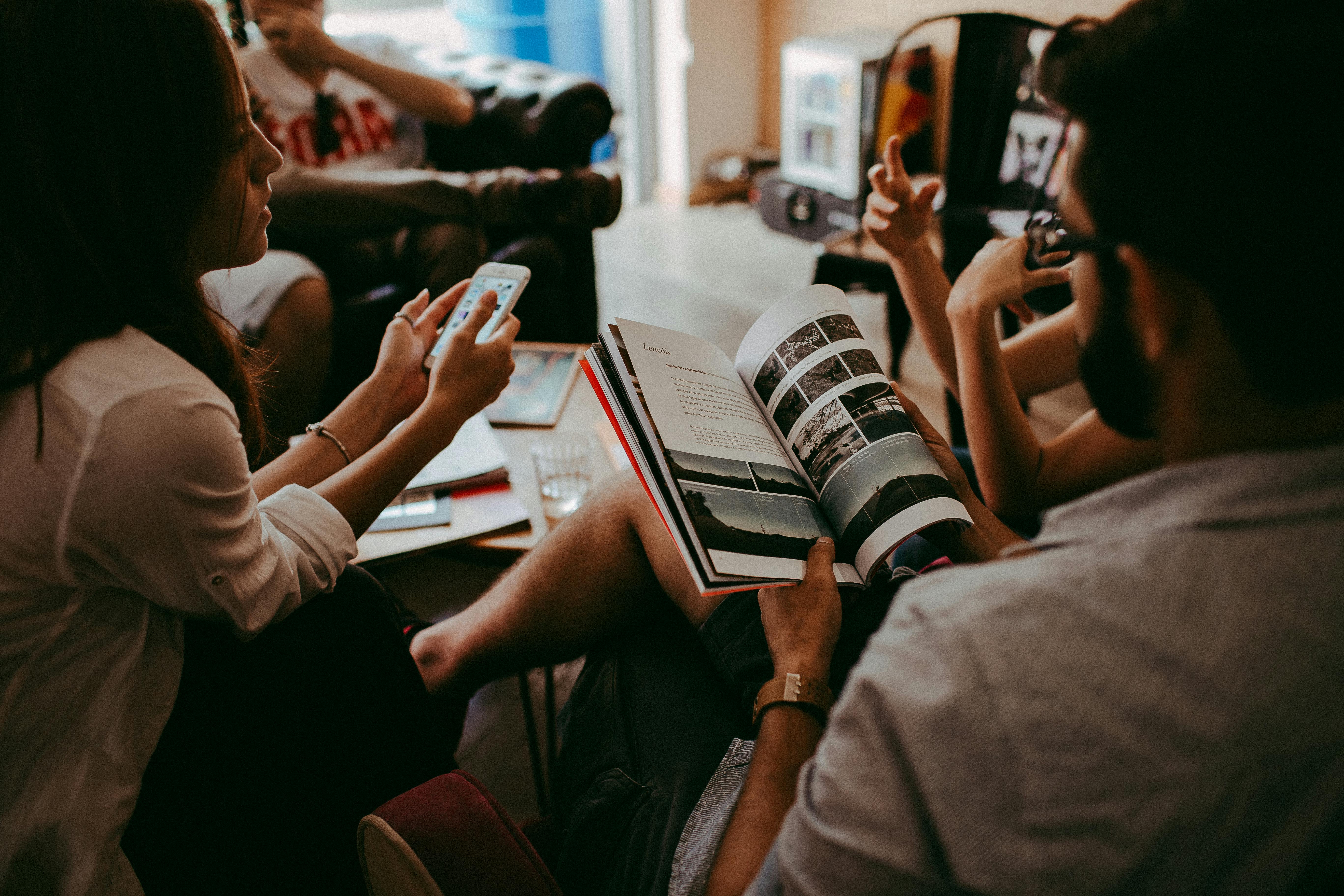 group of people reading book sitting on chair