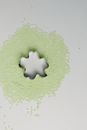 A Silver Steel Clover Molder Surrounded by Beads on a White Surface