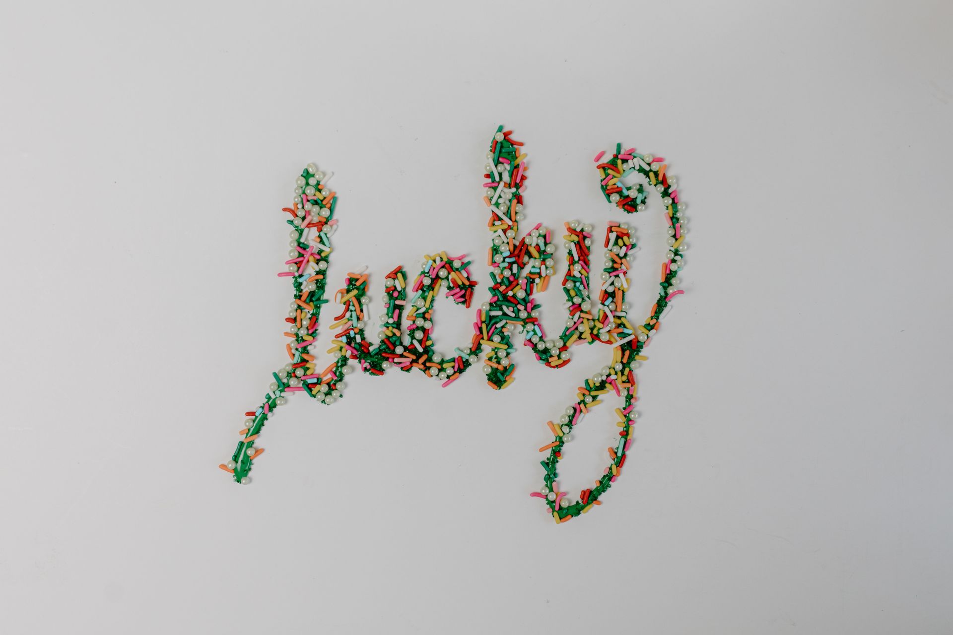Green Icing Text With Colorful Sprinkles