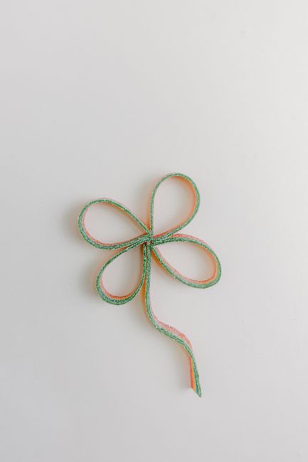 Creative clover-shaped ribbon on a neutral background, perfect for St. Patrick's Day themes.