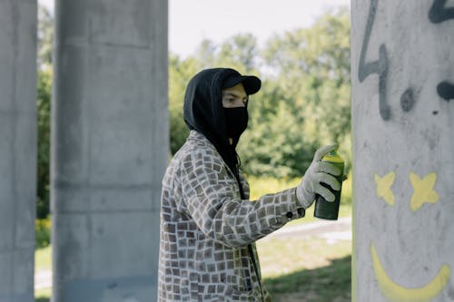 Man Spraying Paint on a Concrete Column