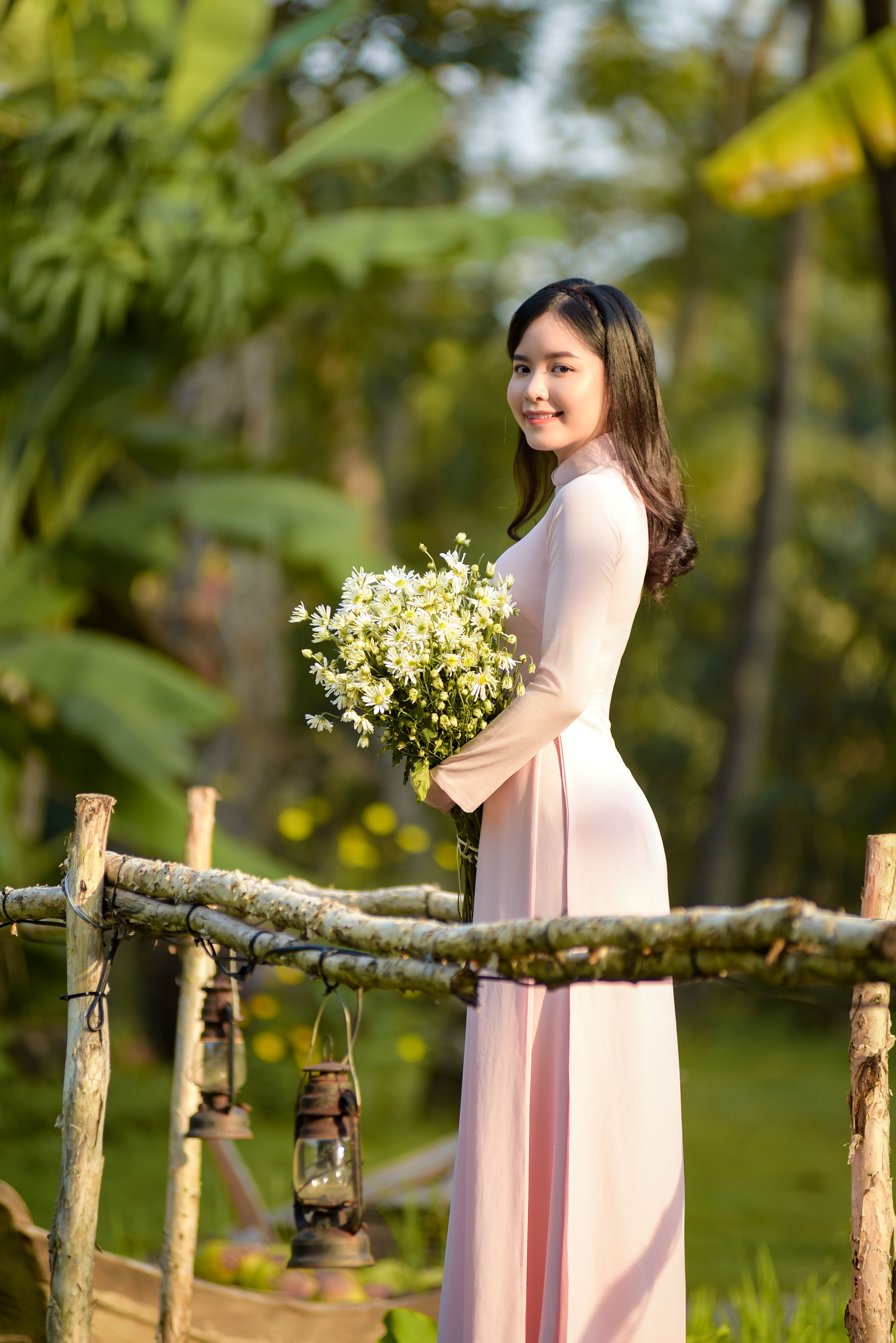 Side view of a woman with a bouquet in a natural outdoor setting.