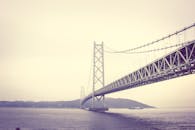 朦胧背景中，一座横跨大海的吊桥景色壮丽