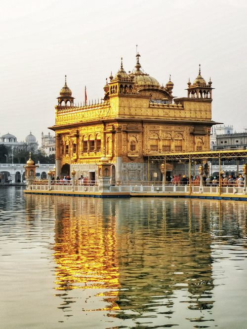 Free The stunning Golden Temple in Amritsar, India, reflecting in serene waters at daytime. Stock Photo