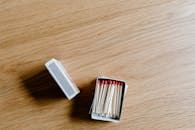 White and Red Match Sticks in a Box on Wooden Surface