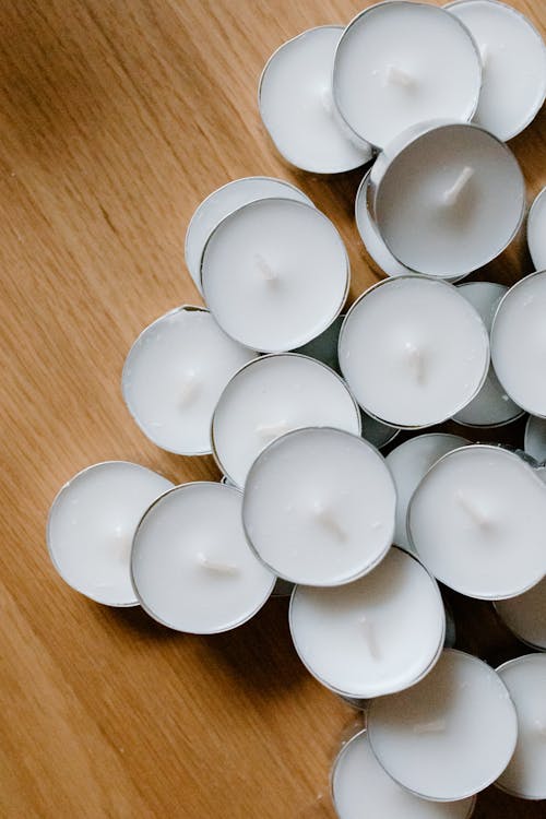 Free A Pile White Tealight Candles on a Wooden Surface Stock Photo