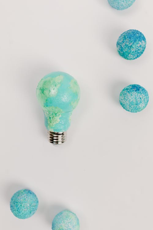 Green and Blue Painted Lightbulb on White Surface