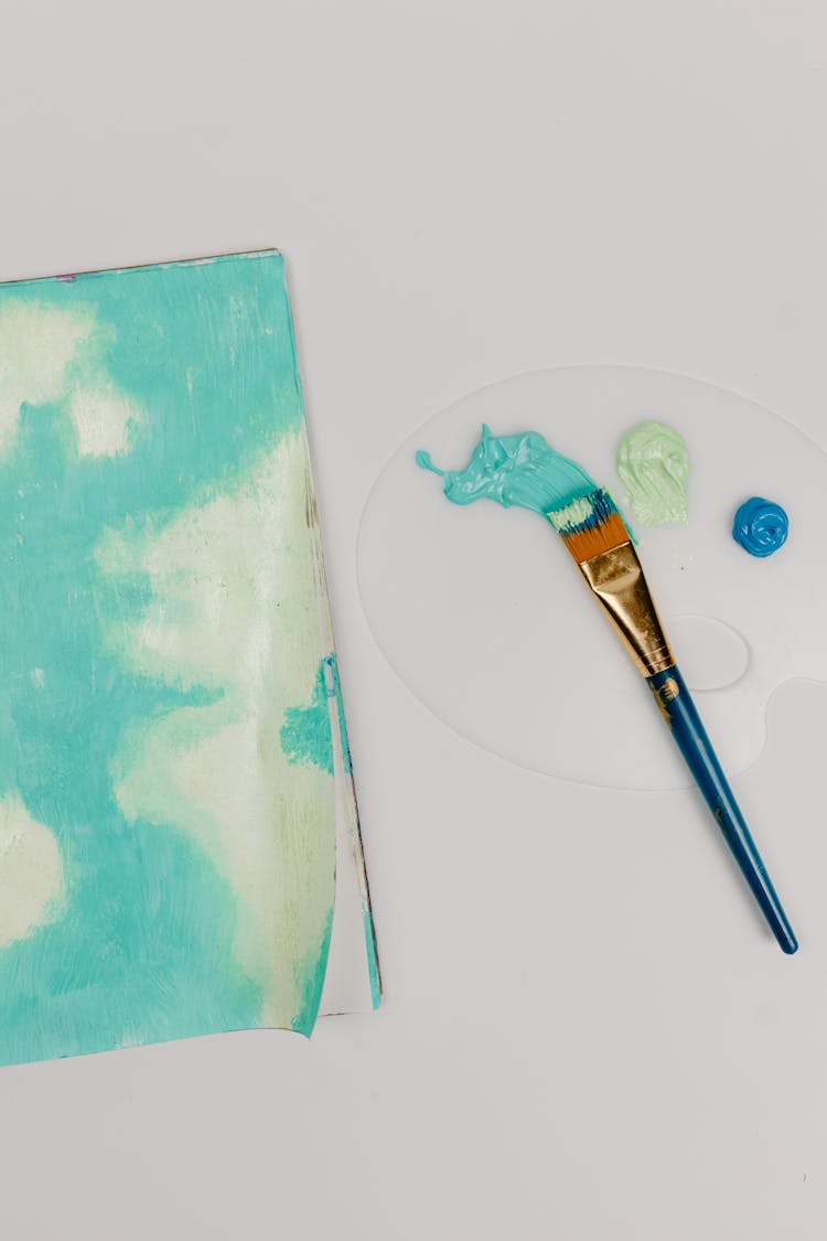 Teal And Blue Paint On Palette Tray Beside Painted Paper