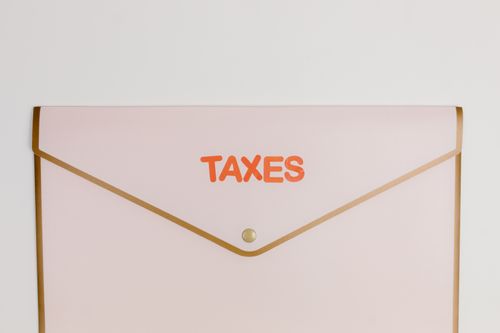 Free Minimalist pastel pink envelope labeled 'TAXES' perfect for finance or tax-themed visuals. Stock Photo