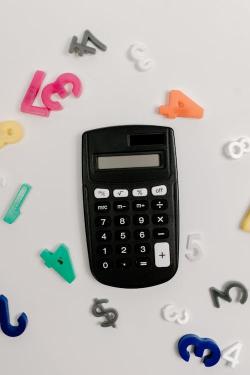 Calculator and Plastic Letters on White Table