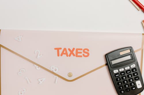 Folder and Calculator on White Table