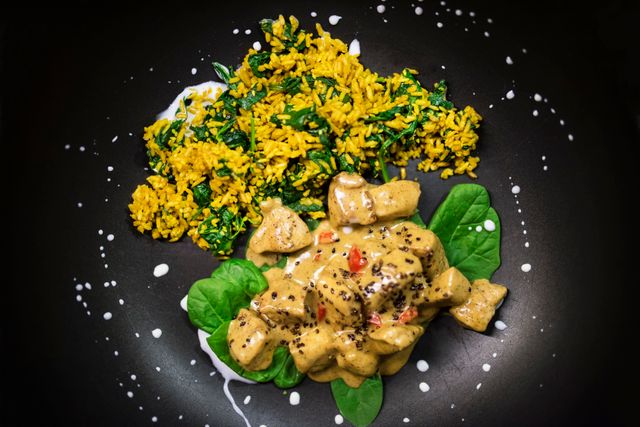 Delicious chicken curry with creamy sauce and spinach-infused rice.
