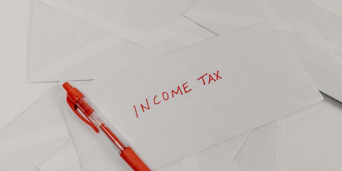 Studio shot of income tax envelope with red pen for accounting and tax season preparation.