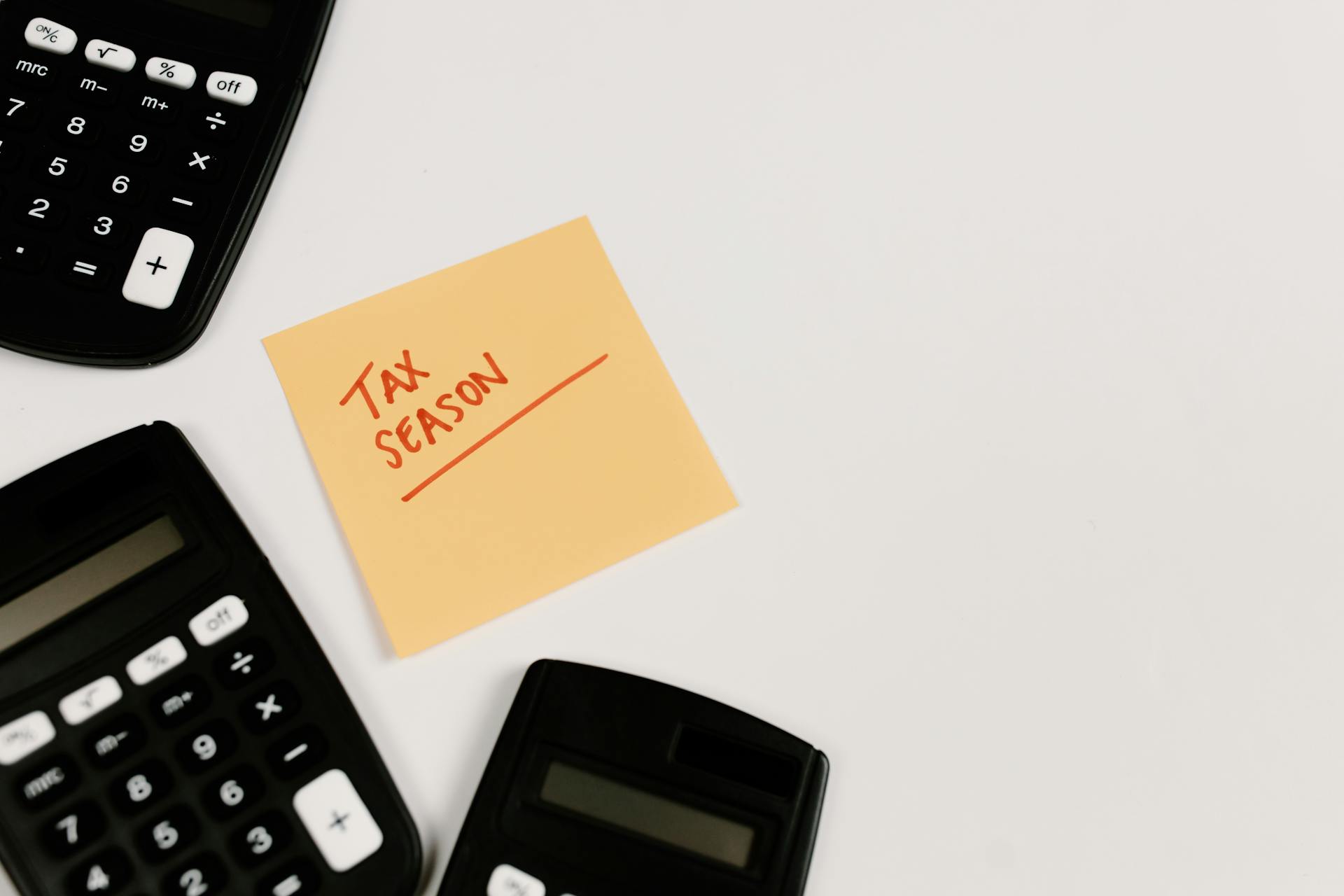 Calculators and sticky note labeled 'Tax Season' on white background, ideal for financial themes.