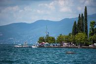 A picturesque Italian lakeside scene with boats and mountains, perfect for a summer getaway.
