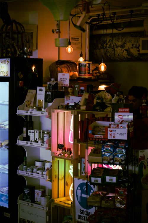 Free Warm and inviting general store interior, featuring stocked shelves and social distancing sign. Stock Photo