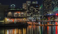 墨尔本海滨的美丽夜色中，明亮的建筑物与水中的倒影交相辉映