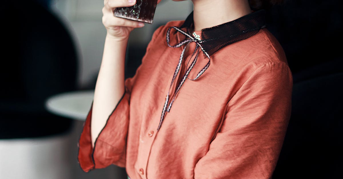 Woman in Pink and Black Dress Drinking Cola