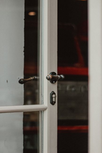 Close-up of a sleek glass door with a stylish metallic handle, exuding modern elegance.