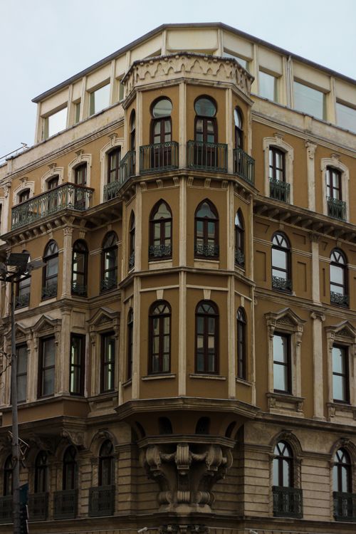 Free Elegant multi-story building facade with vintage European design elements. Stock Photo