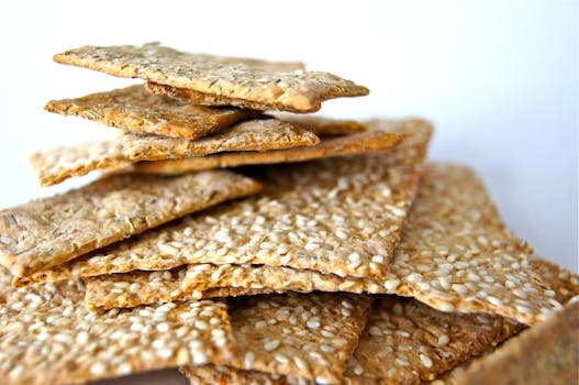 Close-up of stacked sesame seed crackers displayed on a white background.