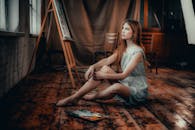 Beautiful Woman Sitting on the Floor While Looking Away