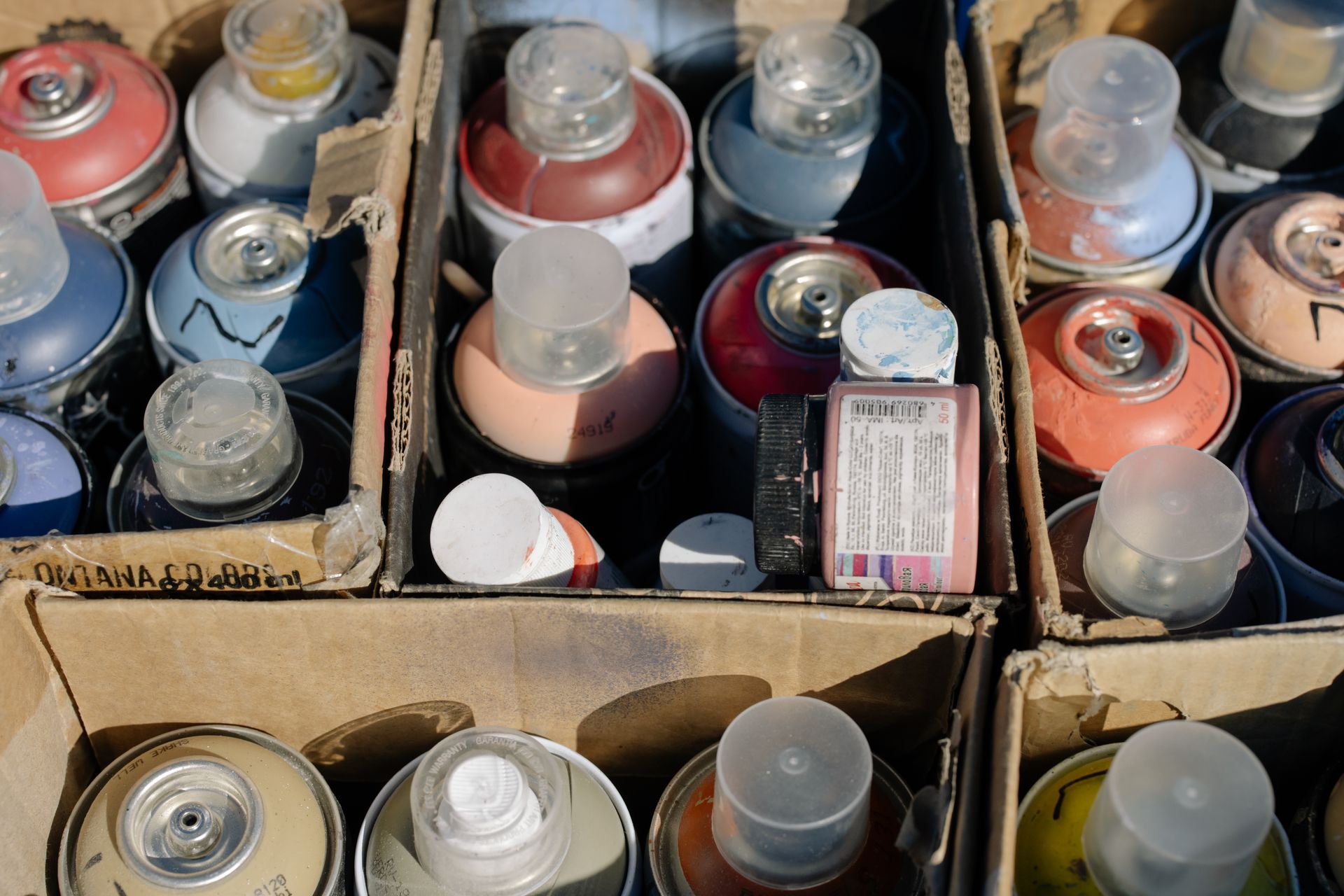 Close-Up Shot of a Spray Paints in a Box