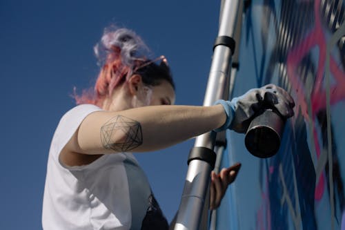 A Woman Doing a Graffiti on a Wall