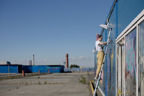 A Woman Doing a Graffiti on a Wall