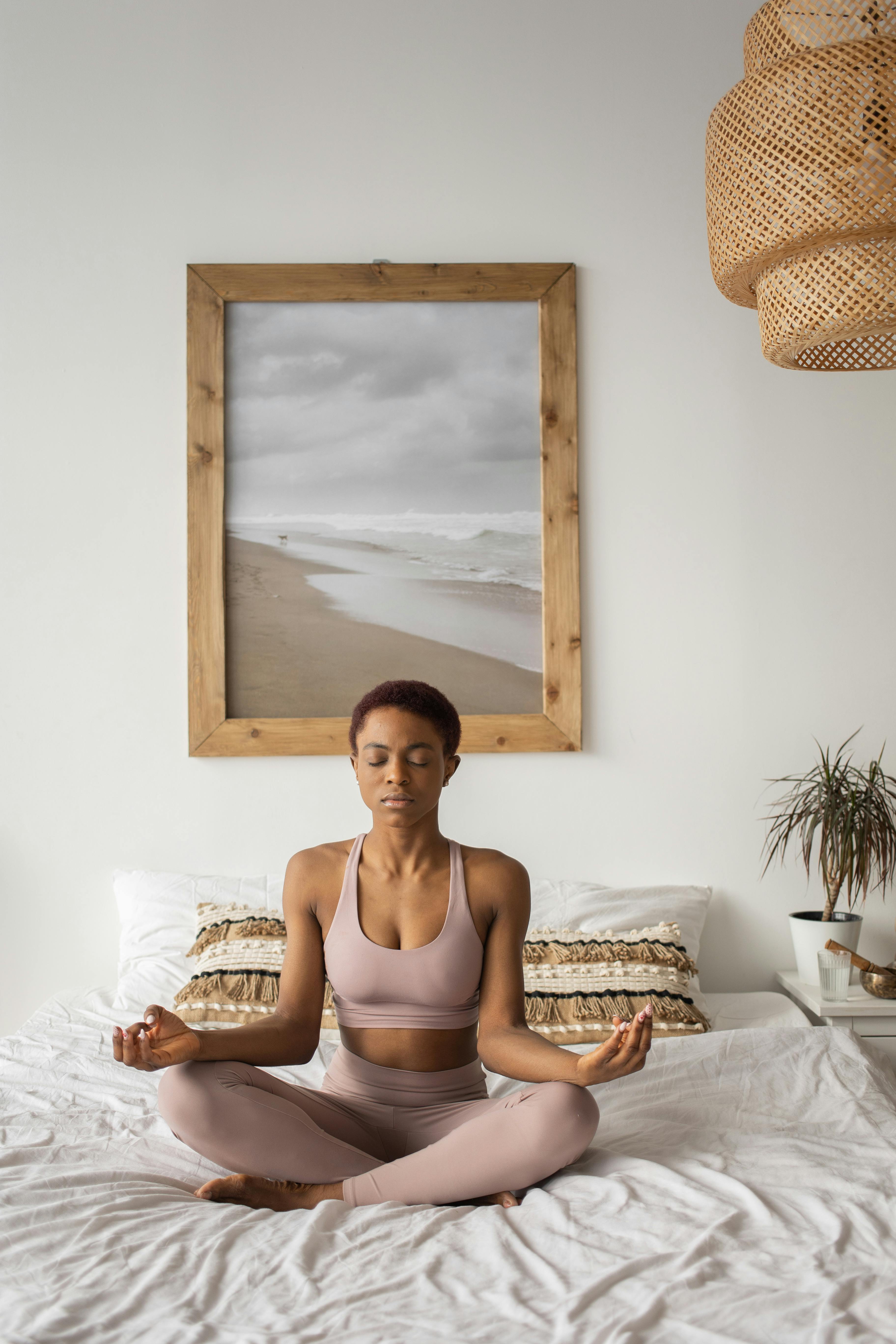 a woman doing a yoga exercise on the bed